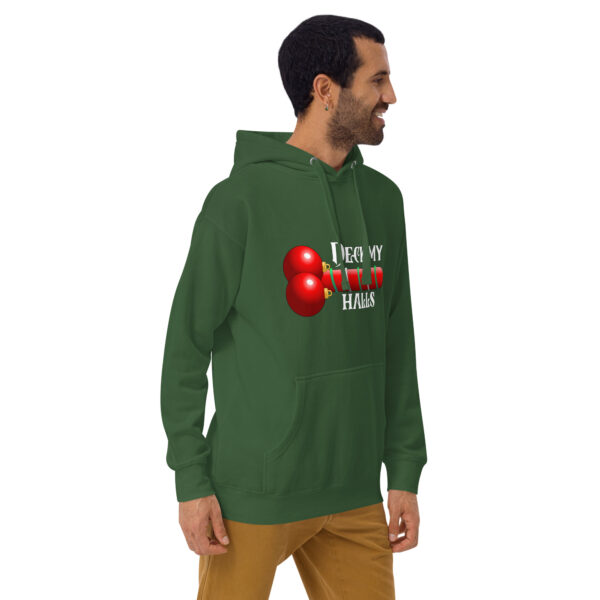 A man in the Deck My Halls Hoodie, featuring a red ball design and text, stands sideways with his hands in his pockets.