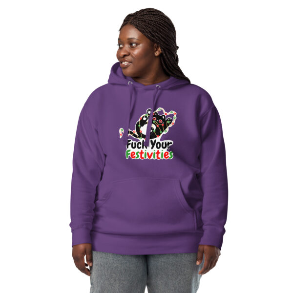 Someone wearing the "Fuck Your Festivities" hoodie featuring a festive Santa cat design on a purple background, standing against a white backdrop.