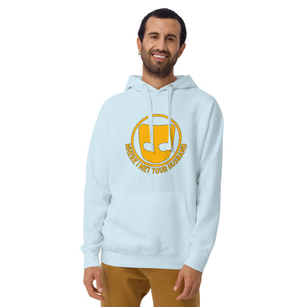 A man wears the "Where I Met Your Husband" hoodie, featuring a light blue fabric with a yellow circular design and text, set against a plain white background.