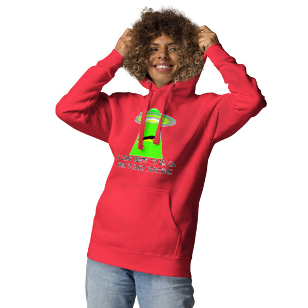 A person sporting the "I don't want to be on this planet anymore" hoodie and jeans, smiling as they adjust their hood, features a neon UFO design.