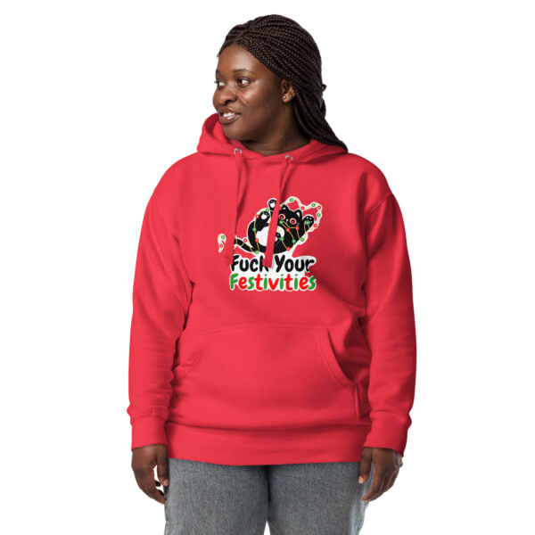 A person wearing the "Fuck Your Festivities" hoodie, featuring a festive design with bold red coloring and text, stands against a plain white background.