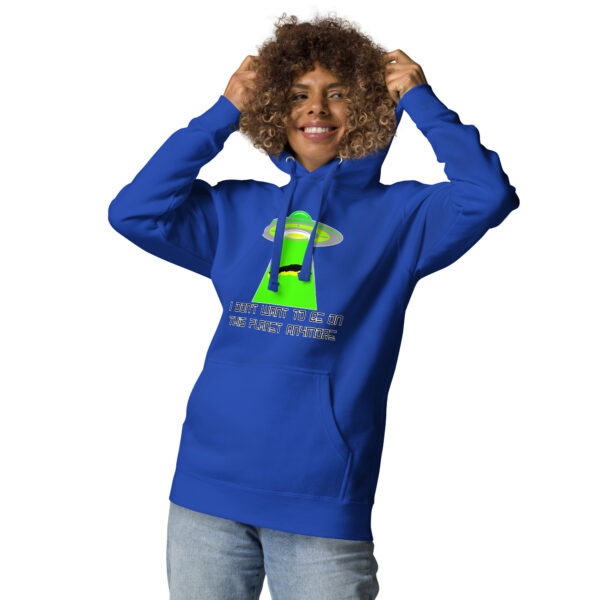 Person wearing the "I don't want to be on this planet anymore" hoodie, featuring a blue color with a UFO graphic and text, standing and holding the hood.