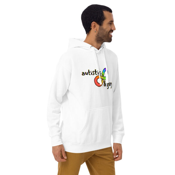 A person is standing and smiling while wearing the "Autistic and Gay" hoodie, featuring a white design with vibrant colors.