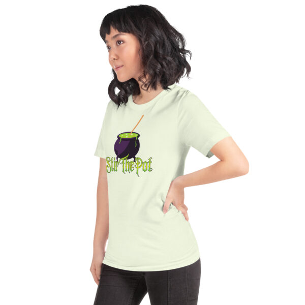 Person wearing a light green t-shirt featuring a purple cauldron with "Stir The Pot" text on the front.