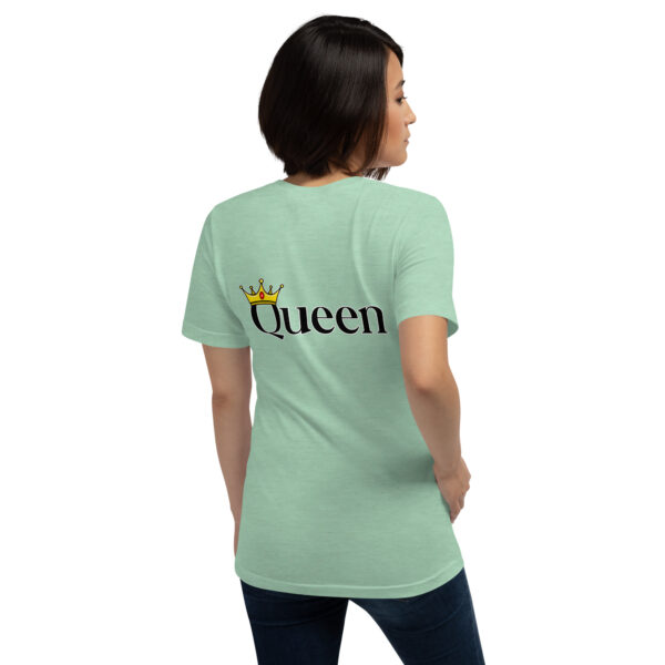 A woman, turning away, is dressed in a light green t-shirt showcasing the "Queen" design and crown graphic on the back.