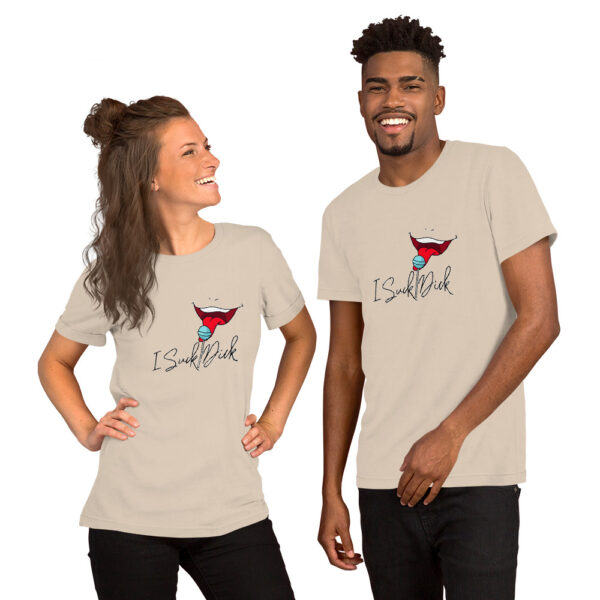 Two people wearing matching light beige t-shirts featuring a stylized "I Suck Dick" superhero logo and text, smiling at each other.