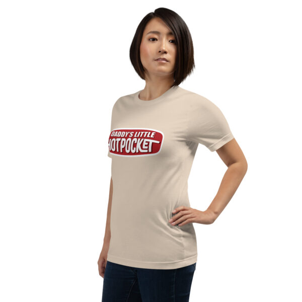 A person wearing a beige t-shirt that says "Daddy's Little Hotpocket" stands with one hand on their hip.