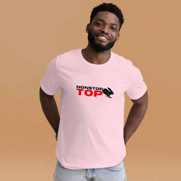 A man smiles while wearing a pink "Nonstop Top" T-shirt, featuring a black and red rabbit graphic, against a beige background.